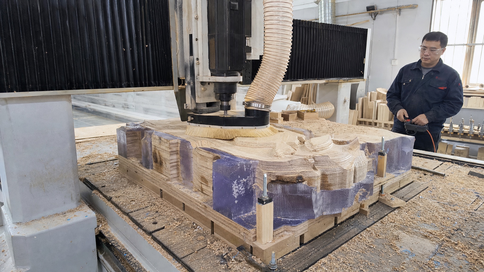 中国工艺师操作 CNC 进行木材树脂雕塑粗加工